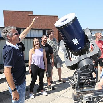 Students check out telescopes at the Paul Tebbe Observatory on the roof of the  Classroom Laboratory Building (CLB)