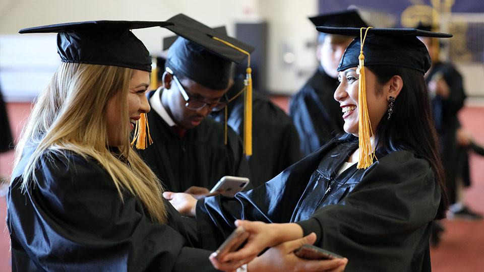 Two JCAE grads embrace each other during the graduation ceremony.